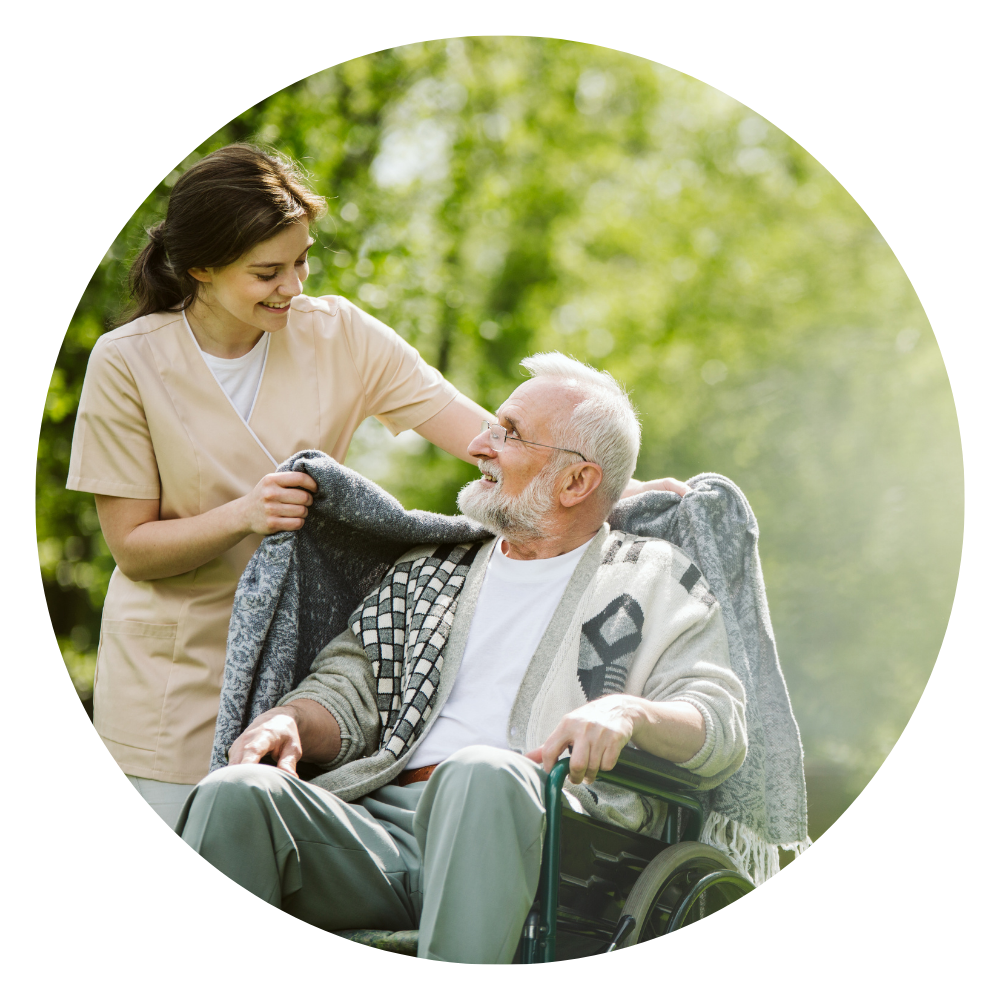 Eine Pflegerin deckt einen Rentieren im Rollstuhl zu. unabhängige Pflegeberatung in Dortmund